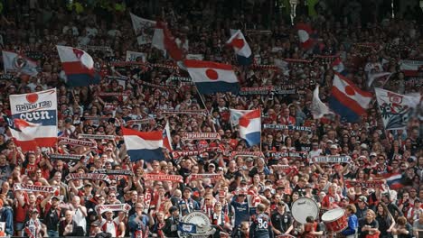 a passionate crowd of supporters cheer for their team with flags and scarves, creating an unforgettable atmosphere in the stadium