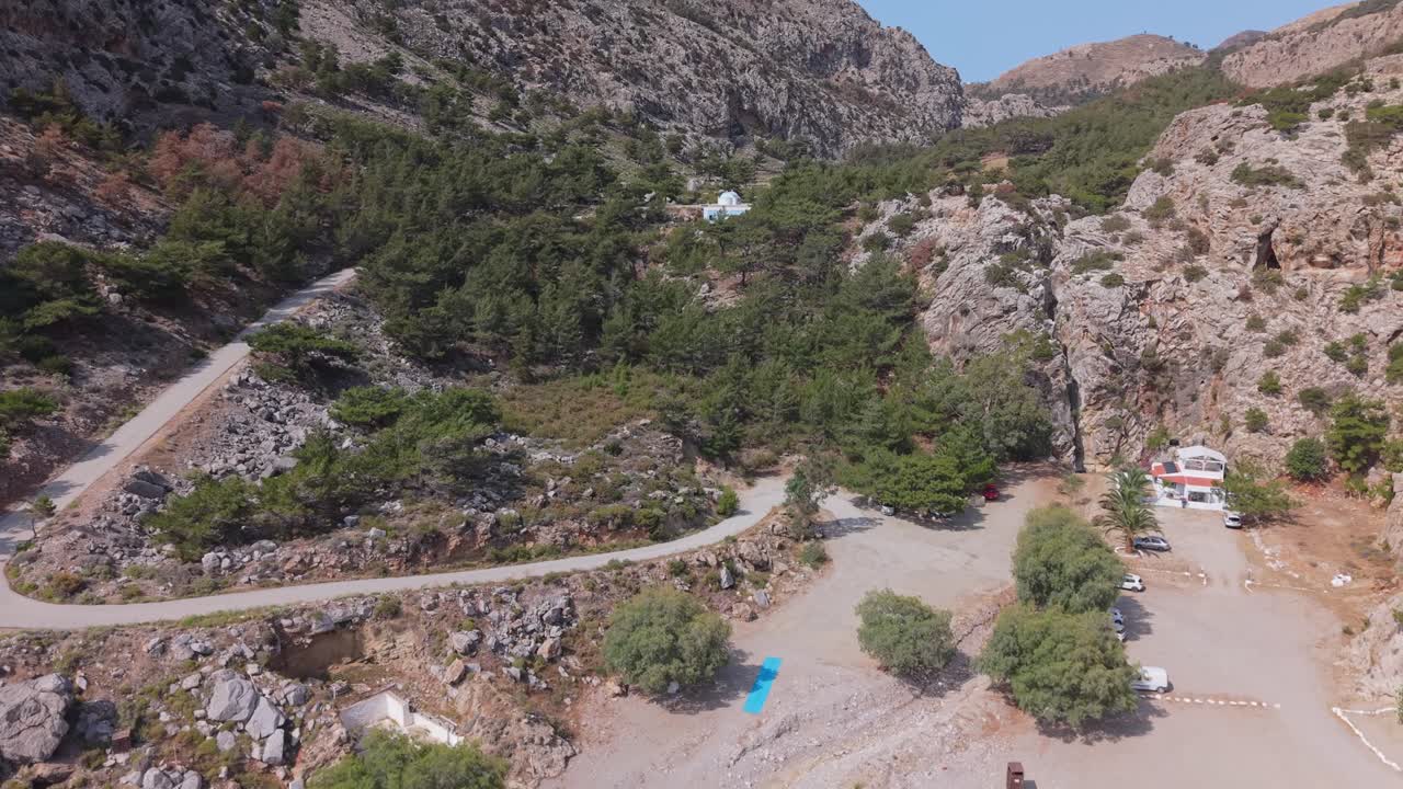 Aerial drone footage revealing the wild beauty of Achata Beach in Karpathos, moving from sea to shore