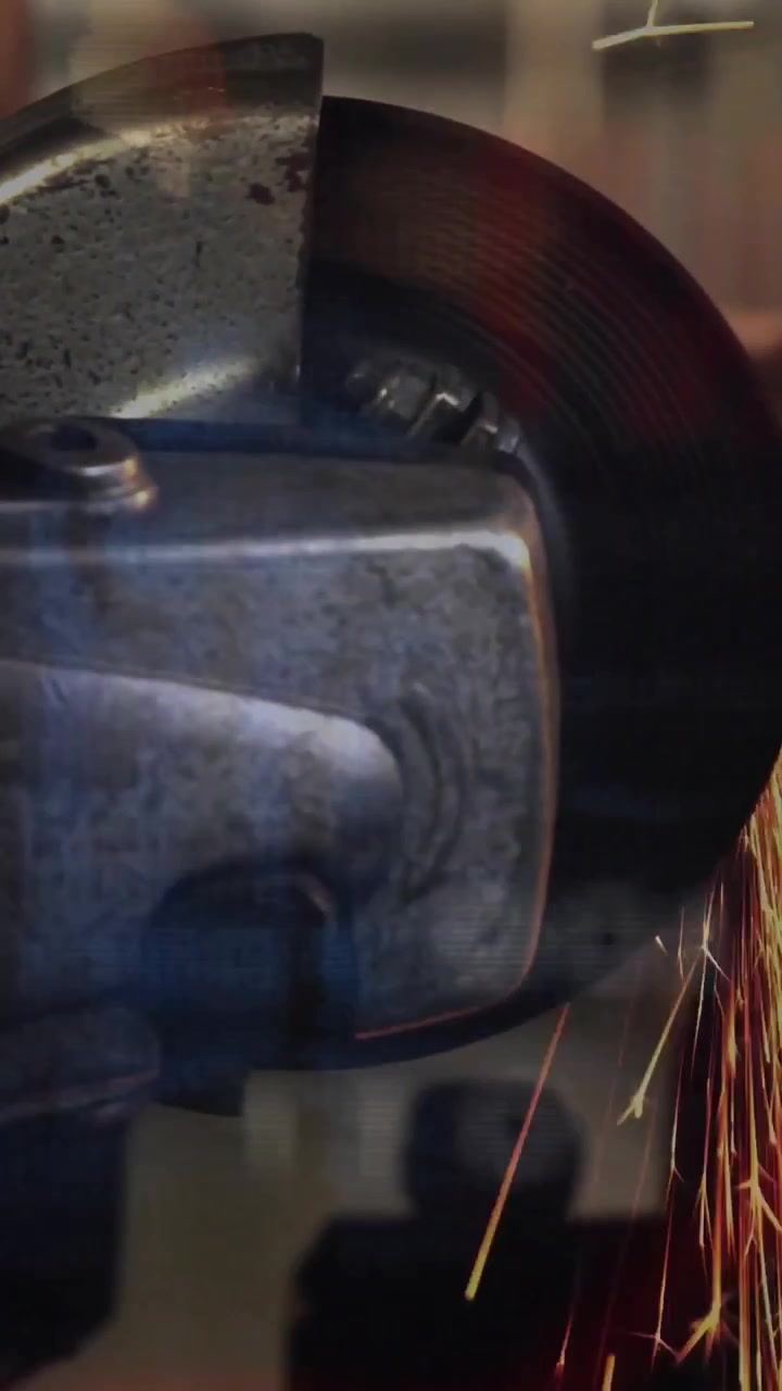 Vertical video: Angle grinder spinning, contacting metal edge and emitting sparks for metalworking