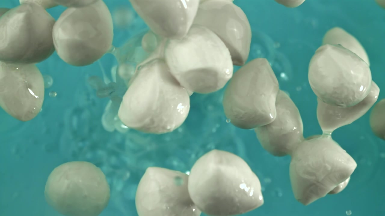 Palline di mozzarella fresca che turbinano in acqua turchese