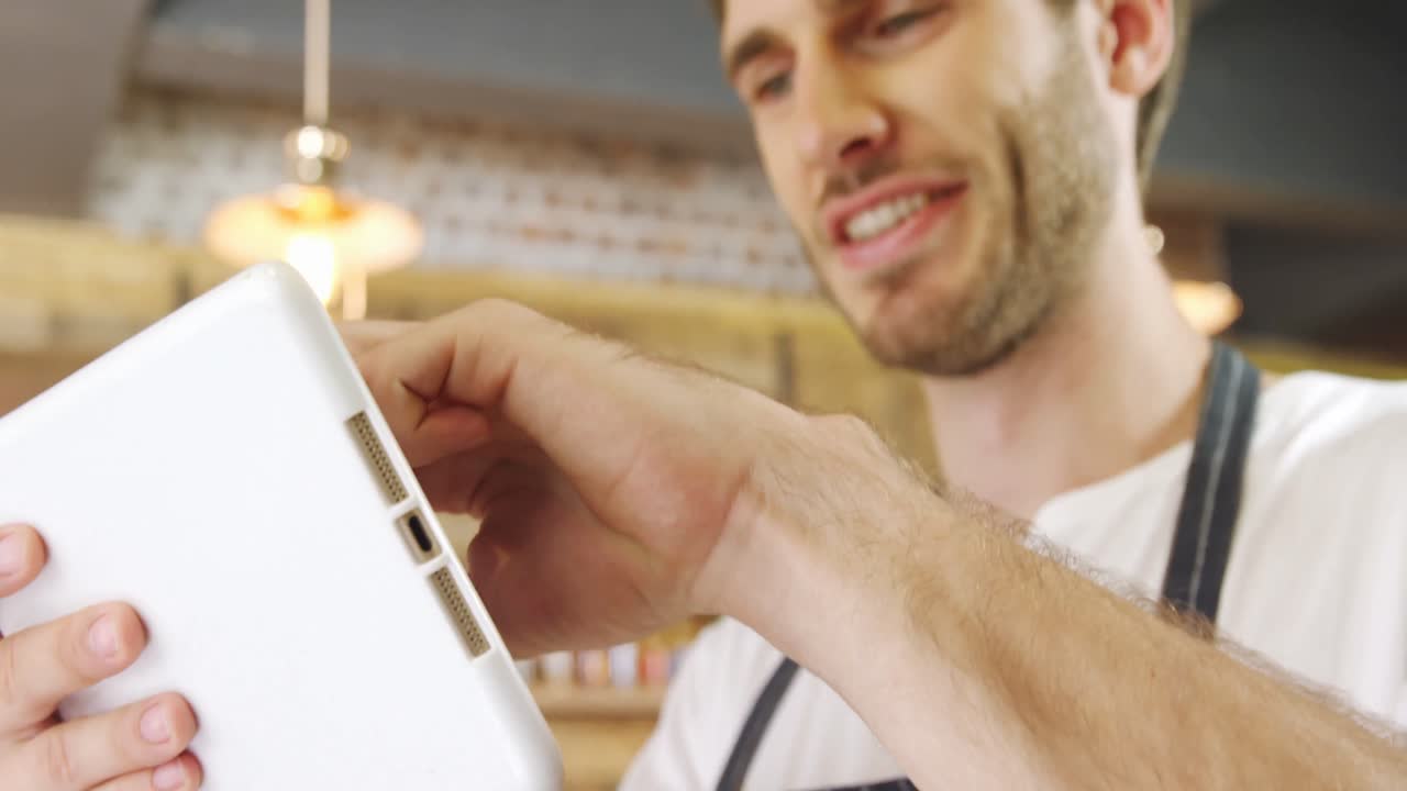 camarero masculino usando una tableta digital en el café 4k