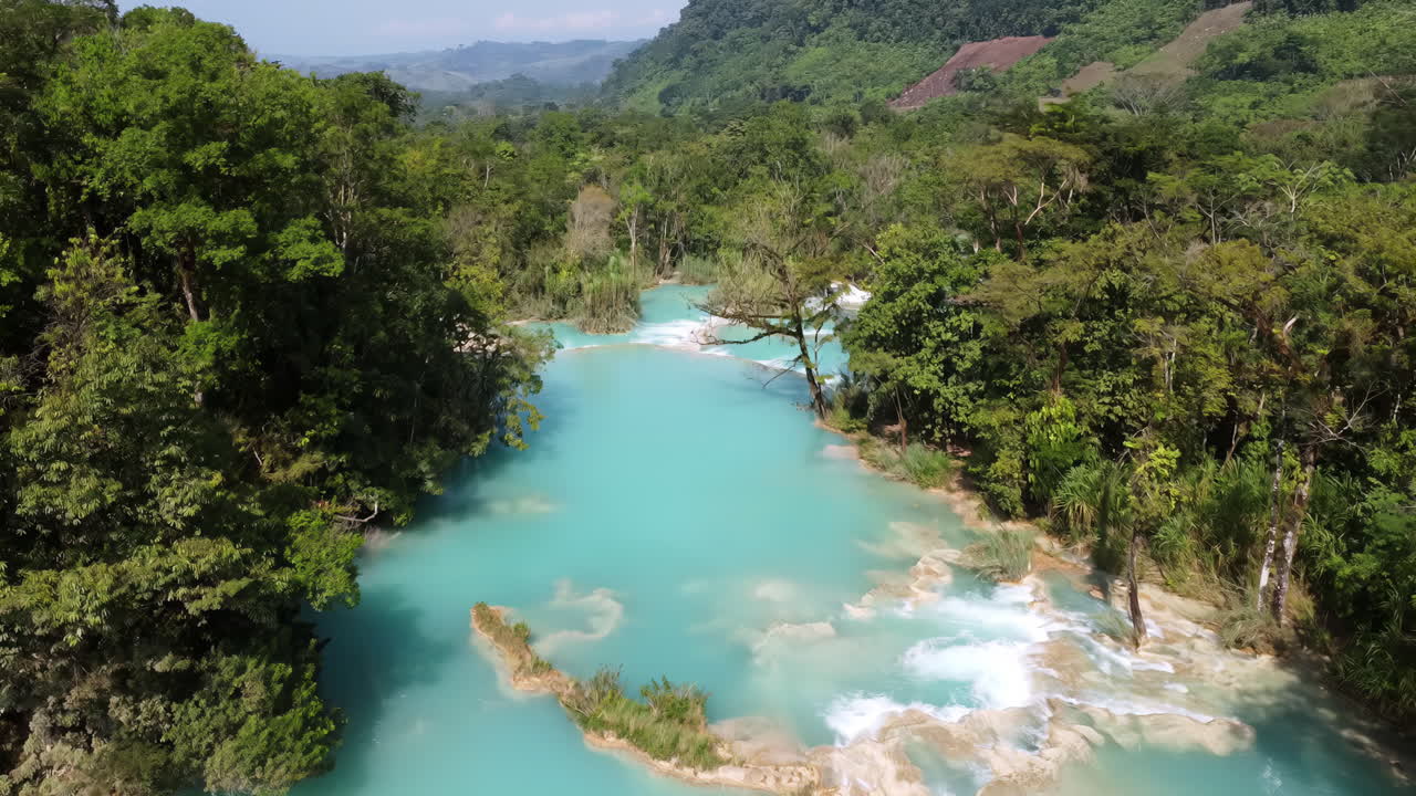 Vista aerea con drone di molteplici cascate turchesi e piscine naturali circondate da una fitta foresta tropicale ad Agua Azul nel Messico meridionale.