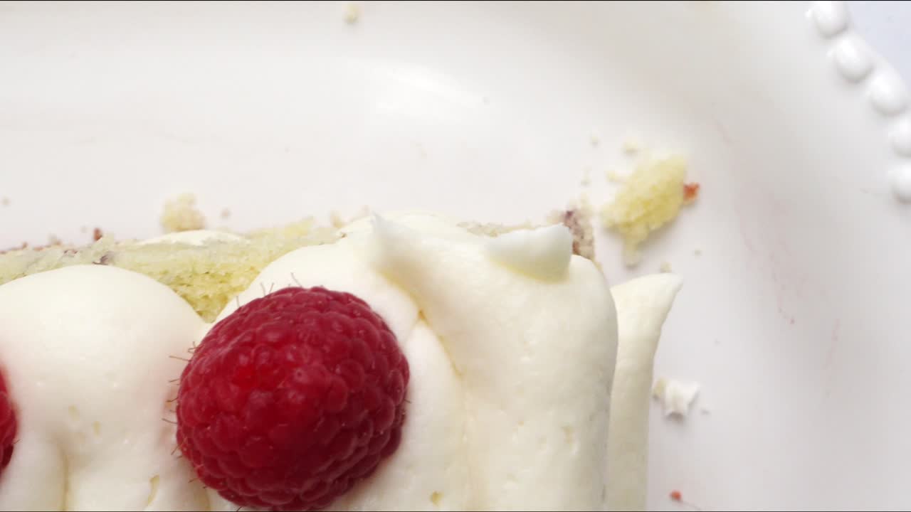 Making a dessert called Red Raspberry Tea Cake made with fresh berries and vanilla buttercream frosting. Great for Tea Parties. Close up of a piece of raspberry tea cake. Panning across the top of it