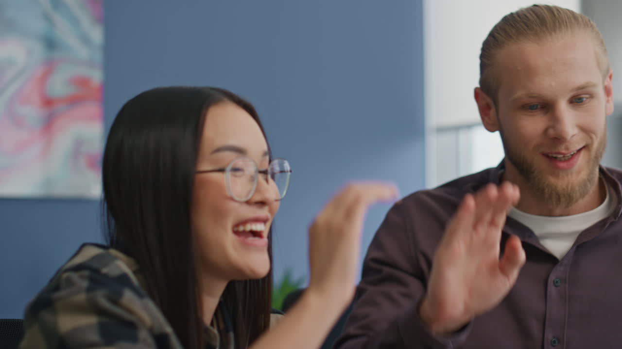 estudiantes felices dando cinco en el piso. colegas multirraciales celebrando el éxito