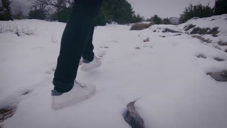 walking in calming winter nature, feet stepping on snow close up