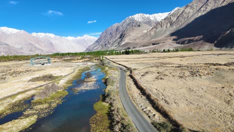 aerial drone shot following a car driving through the barren, high-altitude landscapes of ladakh.