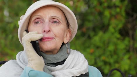 elderly woman talking on a mobile phone outdoors