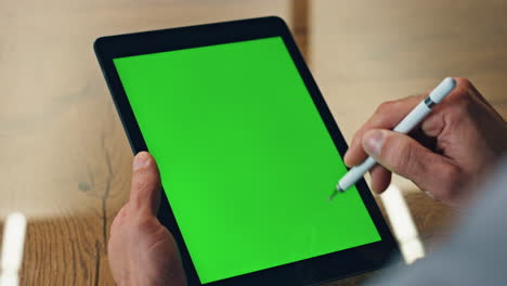 designer hand drawing greenscreen tablet office closeup. artist using chroma pad