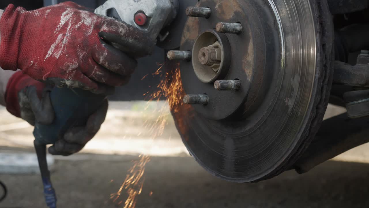 el mecánico corta la rueda del coche con una molienda