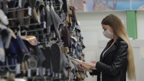 mujer comprando sandalias en una tienda de zapatos durante una pandemia