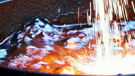 molten metal with sparks in a dark container