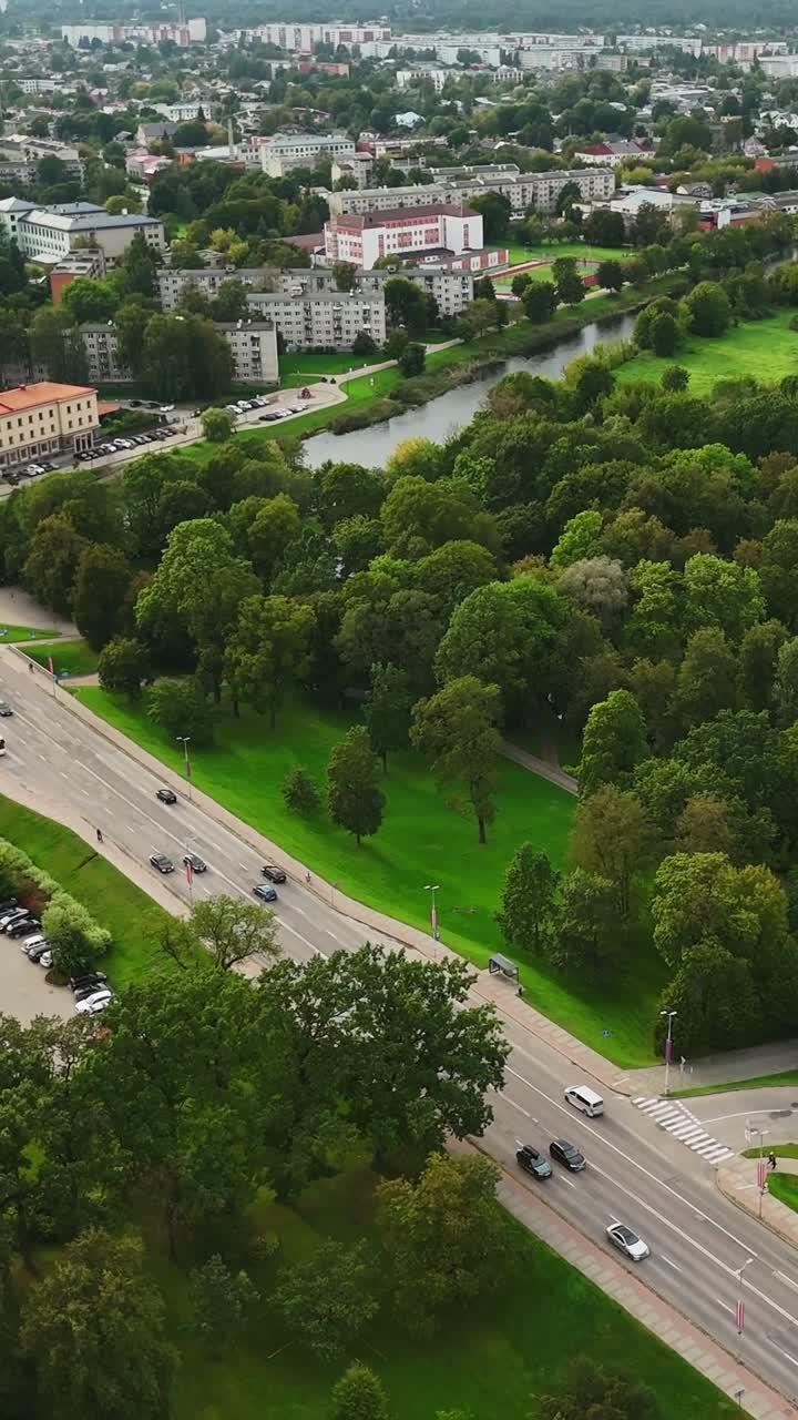 Aerial view of green Jelgava, Latvia with road and parked cars