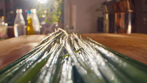 close-macro-camera-moving-along-chives-and-a-male-hand-starting-cutting-it