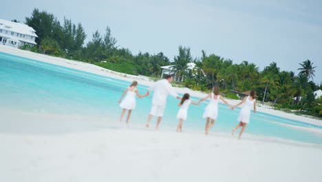 caucasian family together on beach by tropical ocean