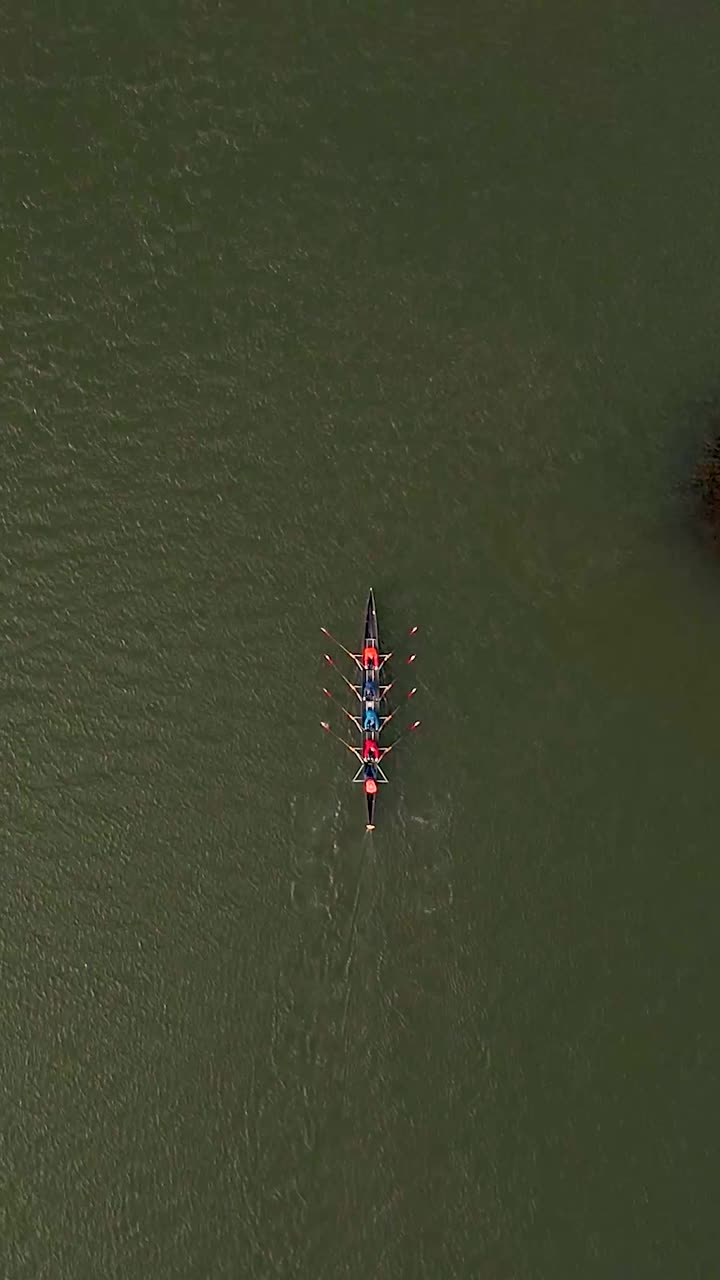 Aerial Top-Down View of a Rowing Crew on Green Water