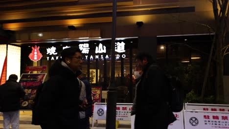 pedestrians walking past shops and restaurants