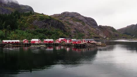 aerial low flying fast footage of the red rorbu houses in the beautiful fisher village of å in the lofoten islands, norway