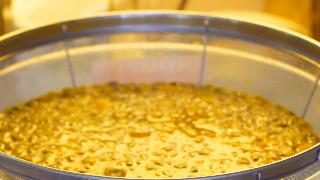 el jugo gotea desde el tamiz hasta el cuenco de la pulpa y las semillas de la fruta de la pasión