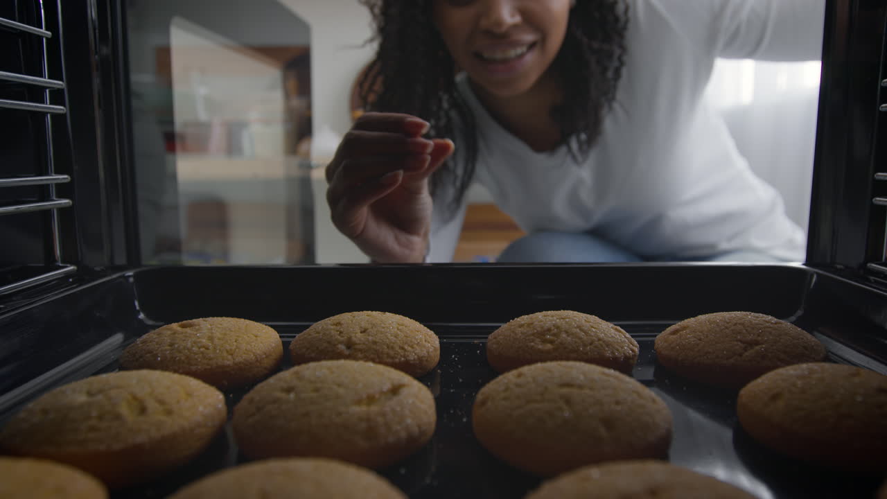 Woman Checking Cookies in Oven