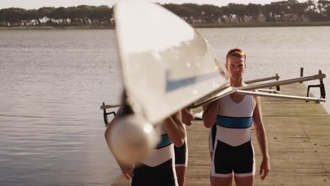 male rower team carrying the boat on their shoulders