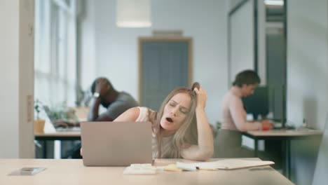 Mujer-Cansada-Durmiendo-Con-Un-Cuaderno-En-La-Oficina-De-Coworking