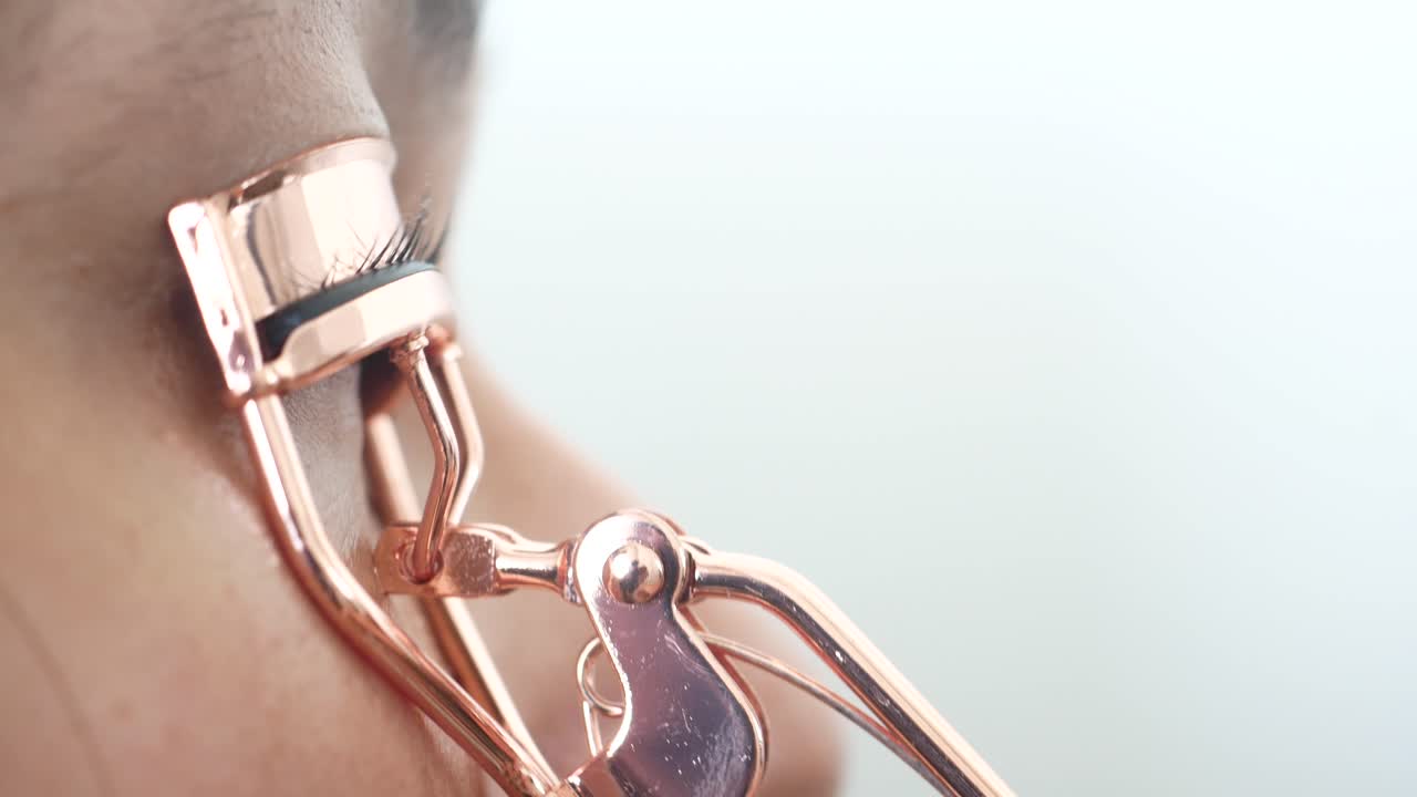 Woman using eyelash curler
