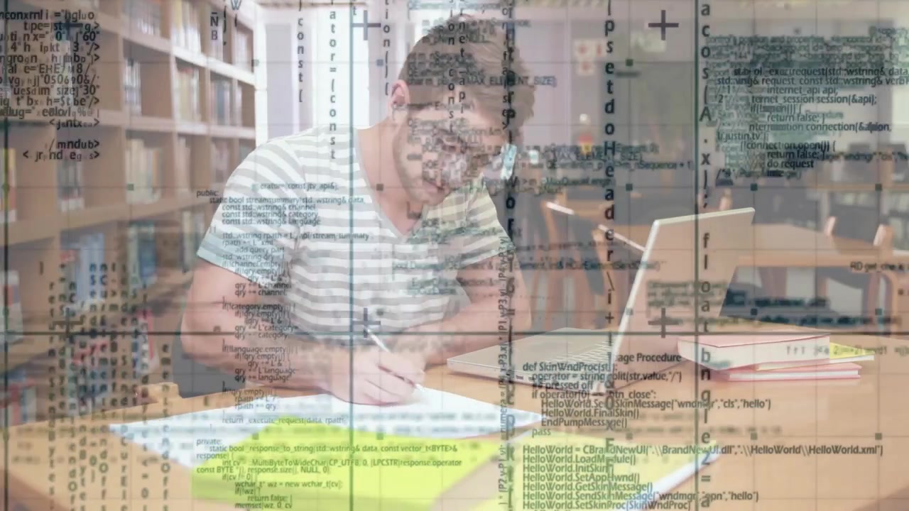 Reviewing notes at library, male student writing and typing on laptop while making study progress