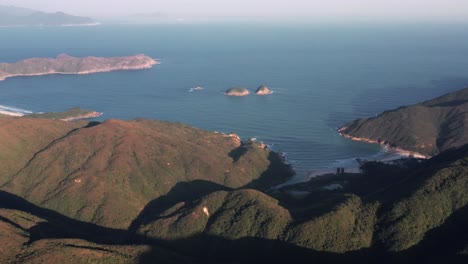 drone view from right to left over the mountain range in hong kong geographical park in sai kung at sunset