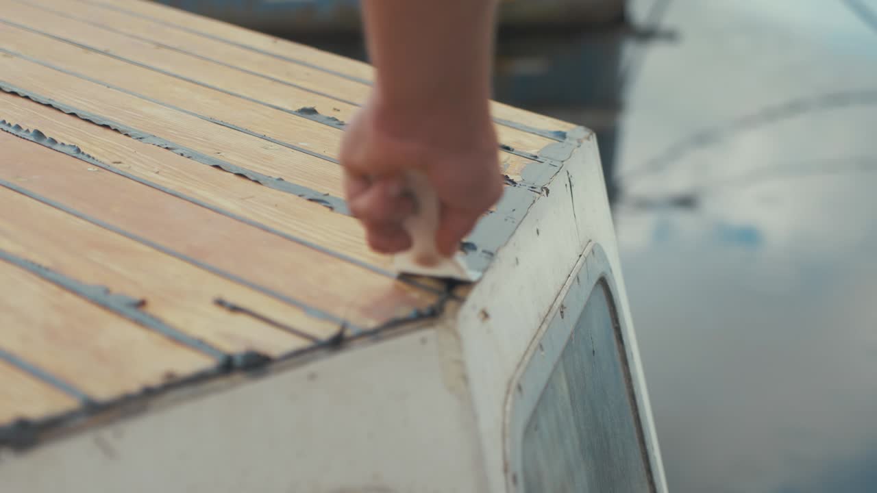 aplanamiento del sellador de masilla sika flex en el borde de la cabina mantenimiento de embarcaciones de madera