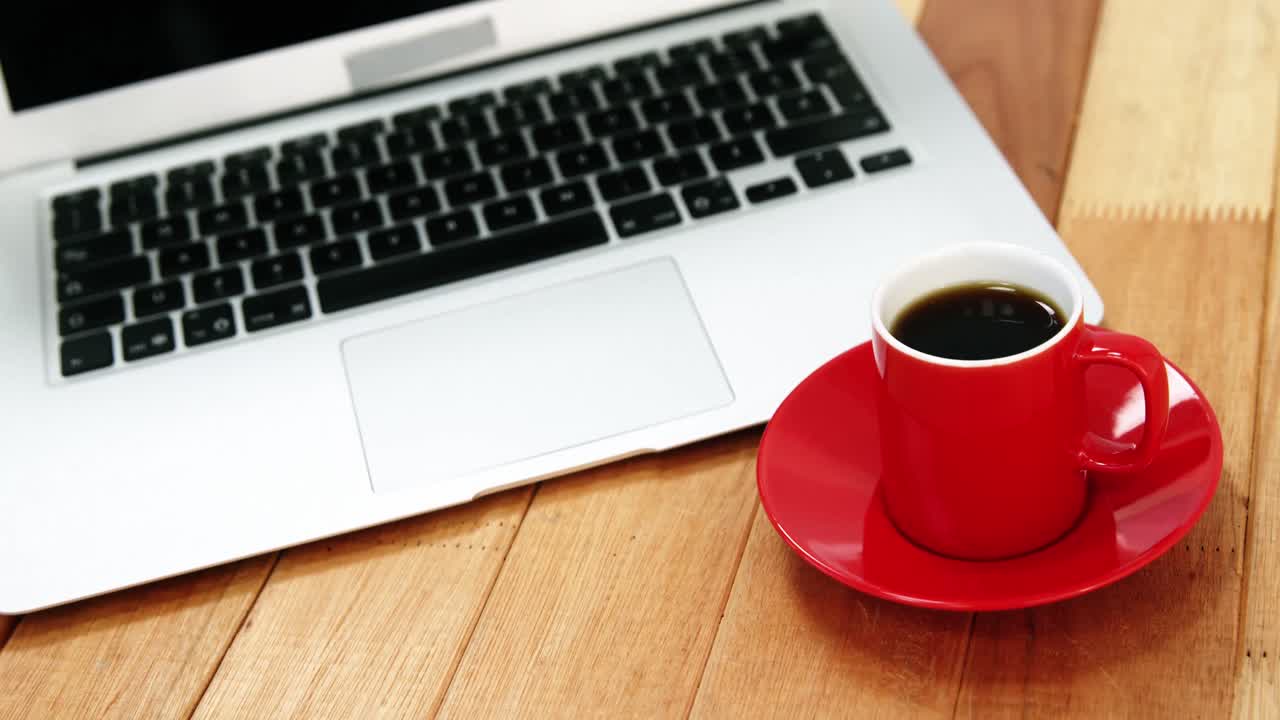Close-up of laptop with coffee cup