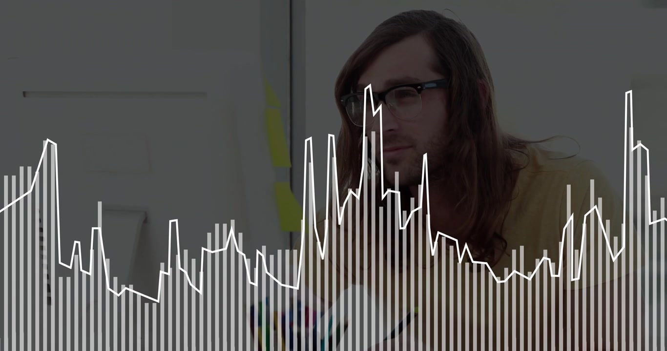 Designer che disegna su un taccuino alla scrivania, con un grafico a barre animato e un grafico a linee per il business