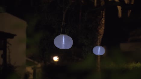 jardín de la casa con linternas de papel blanco por la noche