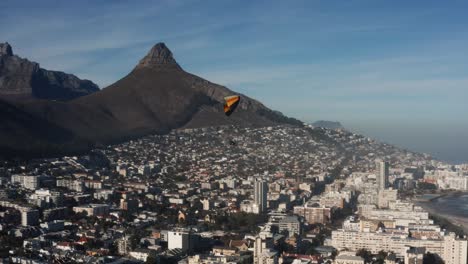 Aerial-Drone-Shot-of-Paraglider-flying-over-Cape-Town-city-in-South-Africa