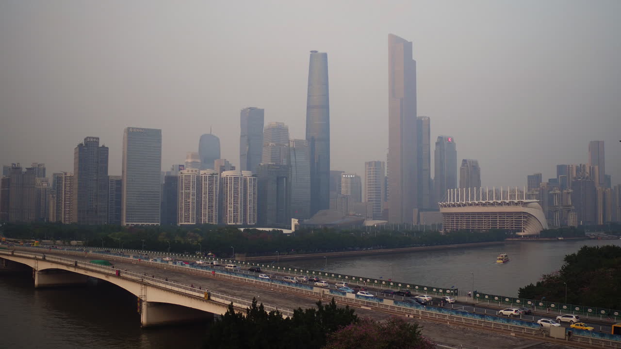 vista del distrito de edificios centrales de guangzhou y el puente de guangzhou sobre el río perla con mucho tráfico por la tarde