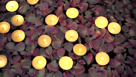 rosas y velas sobre un fondo negro.