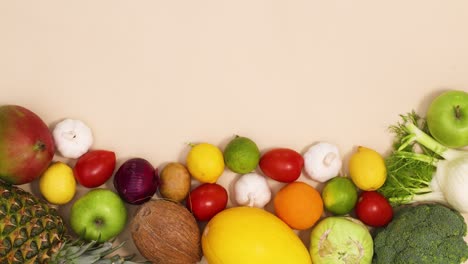 various fresh ripe and organic fruits and vegetables appear on bottom of the table with copy space. stop motion