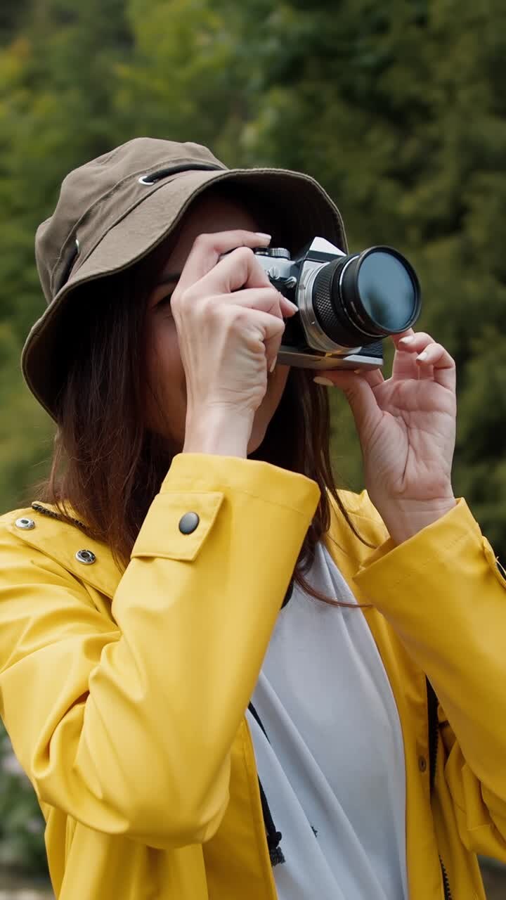 Woman Taking Pictures Outdoors in a Yellow Raincoat