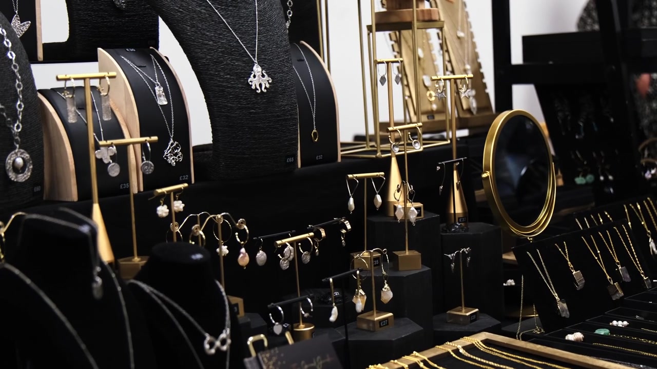 Schmuck an einem Marktstand in Zeitlupe. Stand mit Gold- und Silberketten und Ohrringen ausgelegt