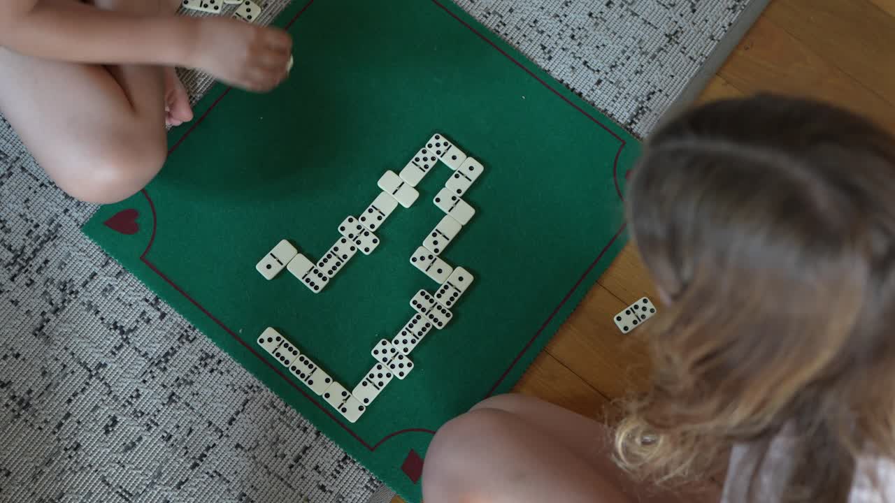 Children playing dominoes game indoors