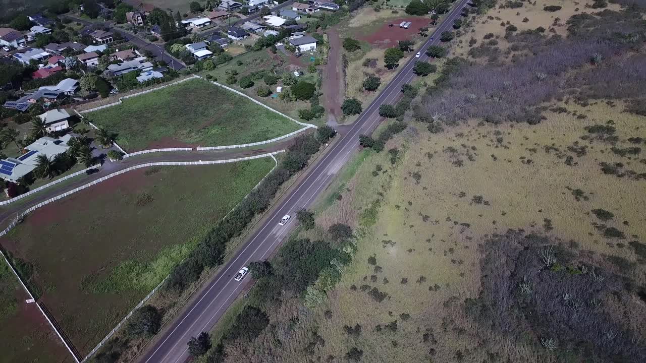 drones rastreando camiones blancos en la carretera en kauai, hawaii y revelando montañas en la distancia en un día soleado