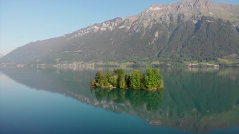 droneshot de pequeña isla en suiza con panorama de montaña en la parte posterior