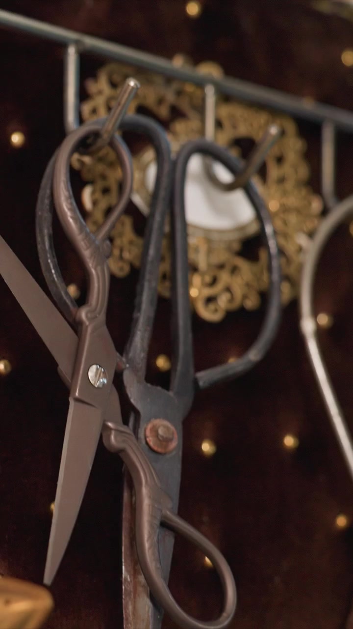 Close up of abacus with wooden beads and white spoon revealing. Camera pans down to show additional tools and hanging objects. Scene includes workshop setting with various tools