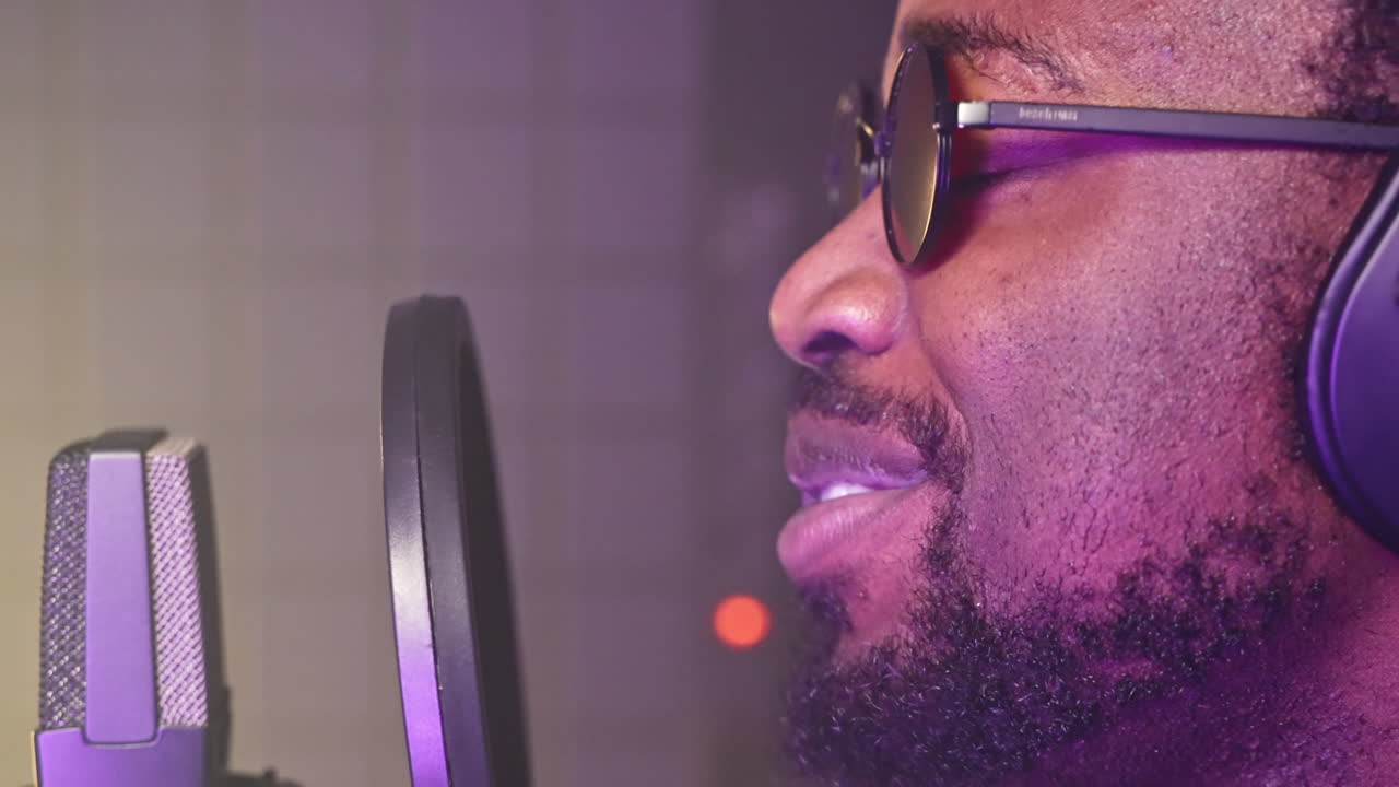 Man Singing Into Microphone in Recording Studio