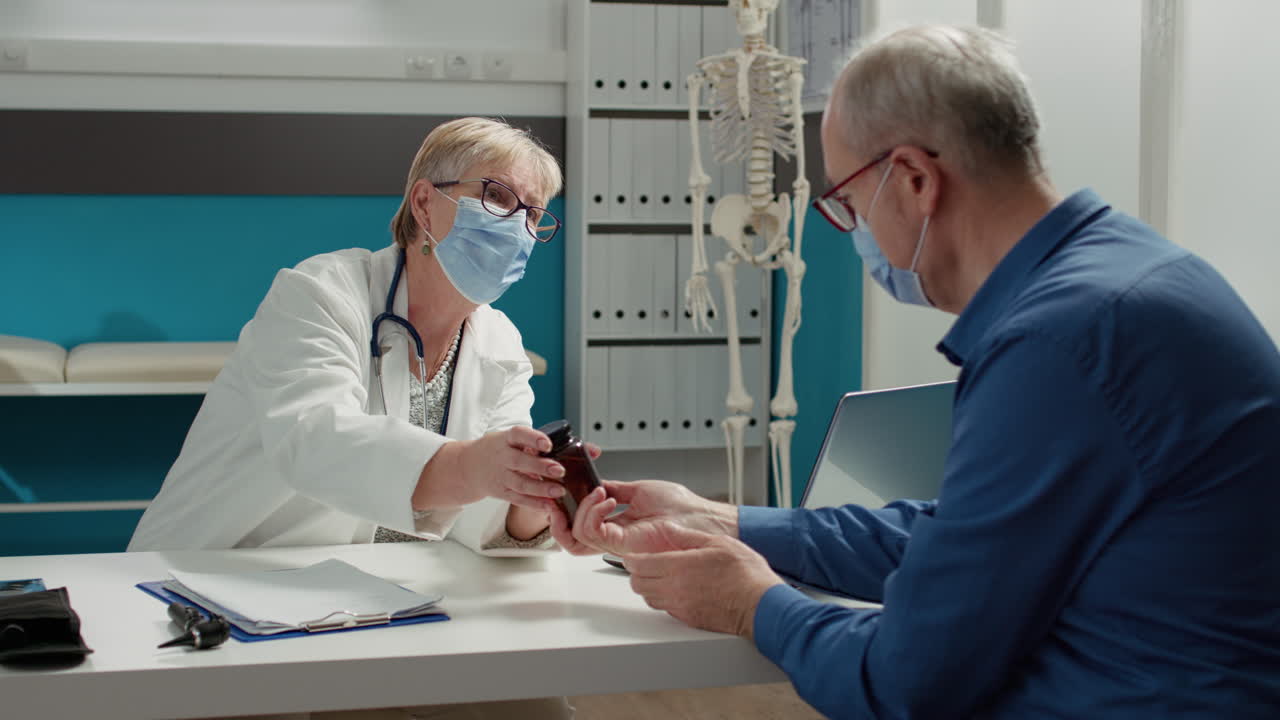 General practitioner and patient with face mask talking about pills bottle