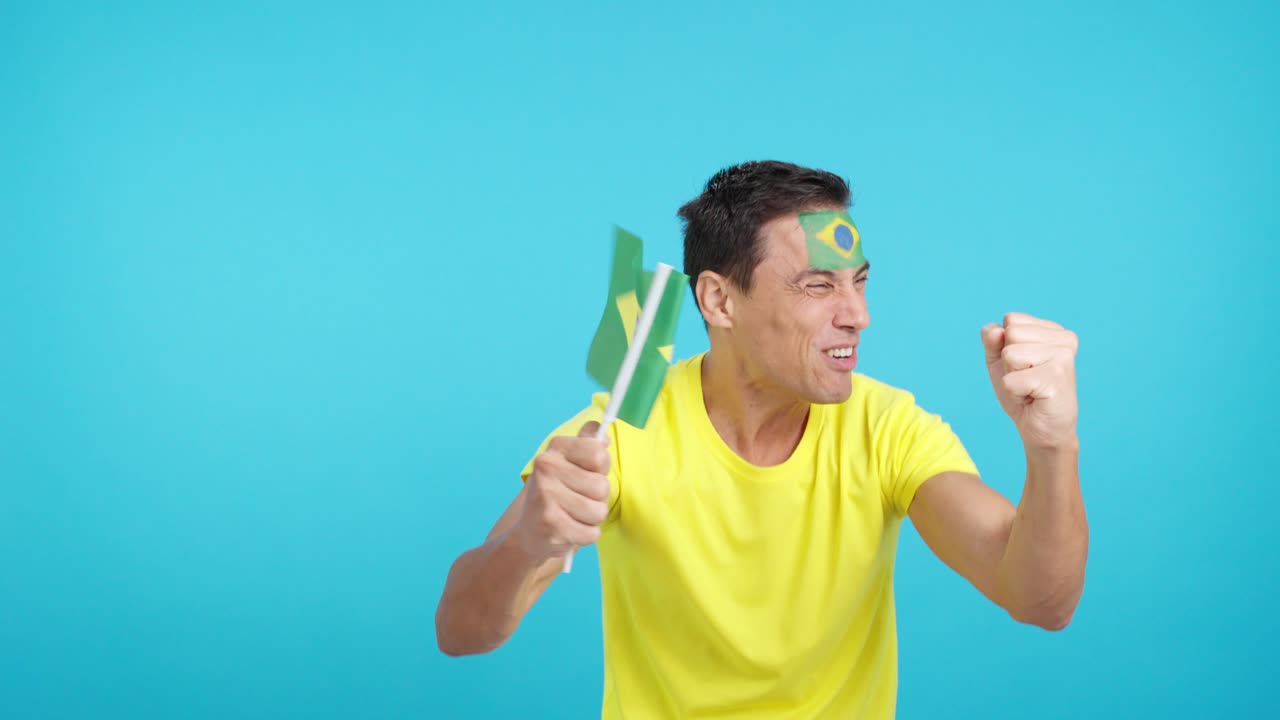 Passionate brazilian supporter screaming and waving a national flag