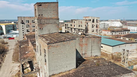 flying over the desolate place with many abandoned buildings in a city after the military actions. ruined city with empty buildings outdoors. aerial view