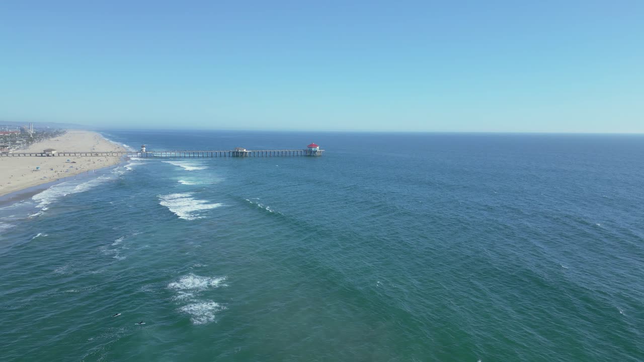 Drone flies over Huntington Beach Pier on a sunny day