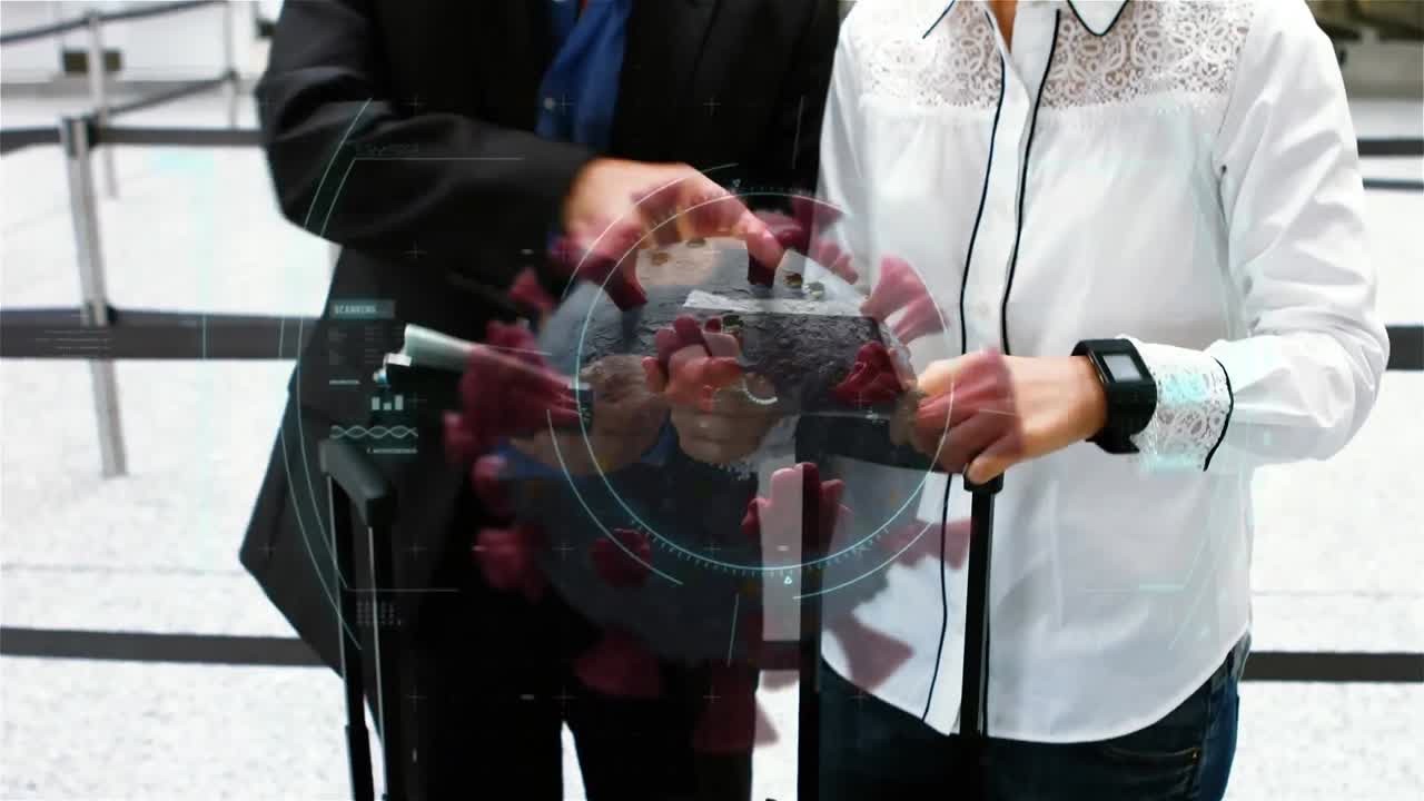 video compuesto digital de escaneo de células de covid-19 contra una pareja de pie en el aeropuerto