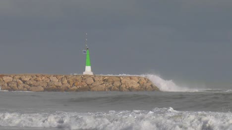 big waves crashing over sea wall at harbor, slow motion