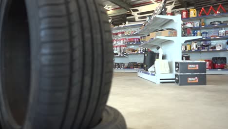 pristine tire selection prominently framing blurred automotive parts store interior, highlighting retail inventory and product range